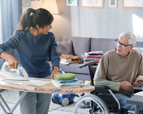 Volunteer helping to senior man with chores